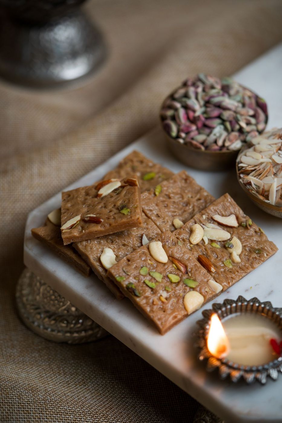 Festive Indian sweets with a lit diya