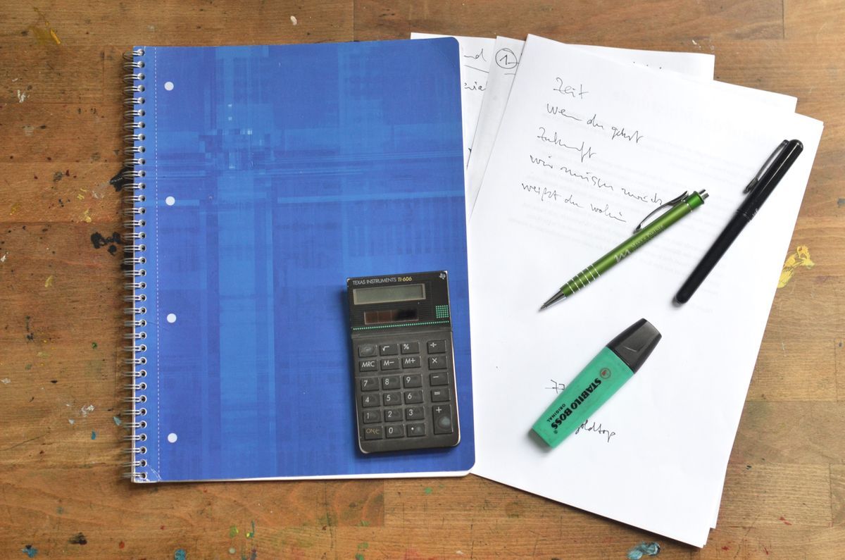 Office stationery — notebook, pens and calculator